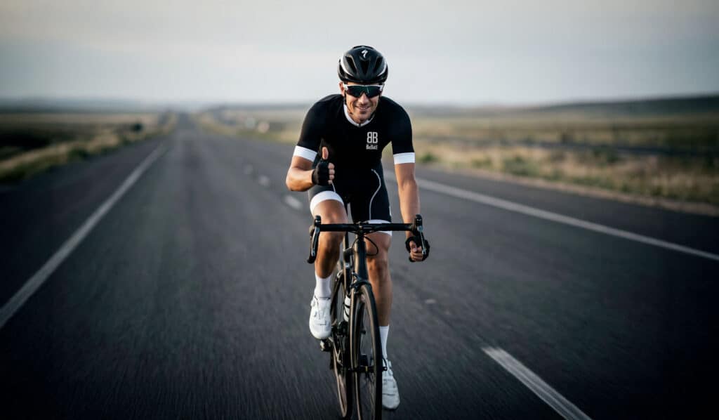 Cycliste en sortie longue distance sur route de campagne au lever du soleil